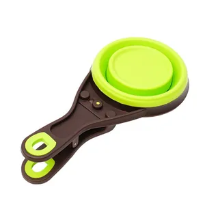 Collapsible silicone pet food measuring scoop with bag clip in vibrant green and brown.