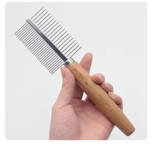 Close-up of pet grooming comb with stainless steel pins and ergonomic wooden handle.