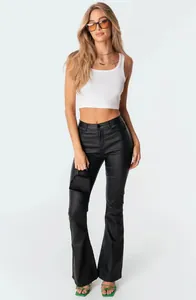 Dettaglio dei pantaloni svasati neri a vita alta abbinati a un crop top bianco alla moda