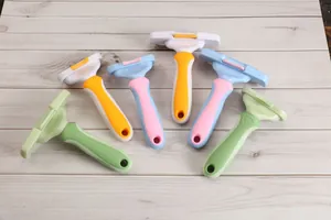 Ergonomische Haustierpflegekämme in verschiedenen Farben auf weißem Holzhintergrund