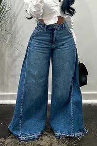 Close-up of blue washed wide-leg denim pants with patchwork design and frayed hem