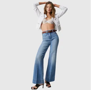 Full-length view of women's stylish blue wide-leg jeans with belt on a plain background.