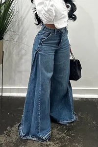 Detailed view of washed blue high-waisted wide-leg flared jeans with raw hem finish
