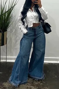 Close-up detail of blue wide-leg denim jeans with unique frayed tiered hem and flare style
