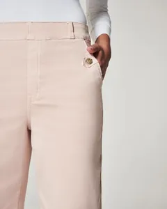 Detailansicht der Seitentasche und des Knopfes an der rosa schmal geschnittenen Schlaghose