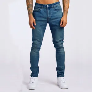 Dettaglio frontale di jeans slim-fit da uomo in denim blu con sneakers bianche