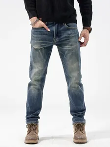 Jeans slim in denim blu da uomo con finitura lavata e dettagli usurati alla moda