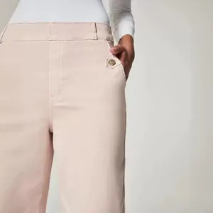 Elegante hellrosa Schlaghose mit hoher Taille und dekorativem Knopfdetail an der Tasche.