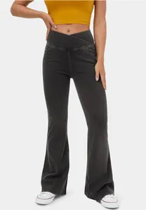 Detail view of high-elastic charcoal flare jeans featuring a crossover waistband