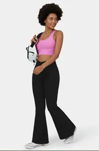 Full body view of high elasticity black flared yoga pants worn by a model in a studio.