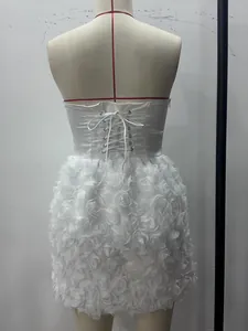 Vista posteriore dell'elegante abito bianco a fascia con gonna a fiori 3D e lacci.