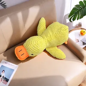 Detail eines weichen Plüsch-Entenspielzeugs für Hunde auf einem Sofa mit Strukturstoff.