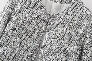 Close-up detail of silver sequined tweed jacket showing texture and fabric