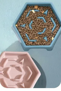 Top view detail of hexagonal slow feeder dog bowls in blue and pink showing maze design