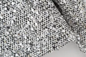 Macro view of textured tweed fabric with silver sequins for spring fashion blazer jacket
