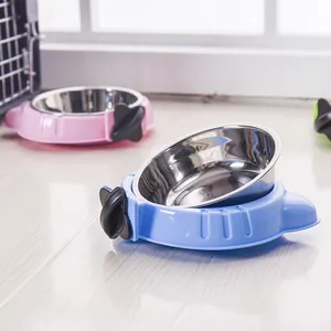 Stainless steel pet bowls with colorful plastic cage-mount holders in a home setting