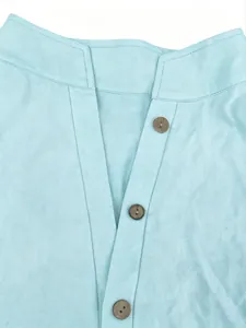 Macro view of light blue linen shirt detail showing wooden buttons and V-neckline
