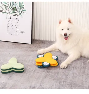 Chien blanc avec un jouet d'alimentation lente en forme de trèfle dans un salon