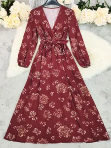 Full view of long-sleeved floral bohemian dress displayed on white faux fur background