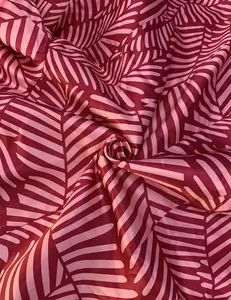 Close-up of pink and burgundy leaf print fabric for elegant women's spring suits