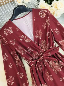 Detailed view of bohemian wine-red floral dress featuring a V-neck and tie waist