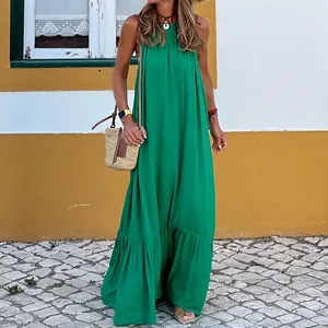 Full-length view of a vibrant green halter-neck maxi beach dress on a model outdoors.