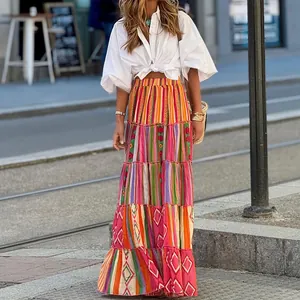 Detail view of a colorful Bohemian tiered maxi skirt styled with a white crop shirt.