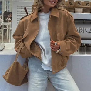 Stylish oversized brown suede bomber jacket styled with light wash jeans and matching bag.