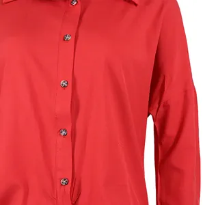 Macro detail of the red fabric and dark buttons on a long-sleeved button-up shirt dress