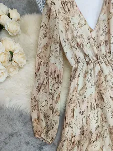 Close-up view of a bohemian V-neck dress featuring abstract marble print and elastic waist
