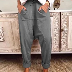 Detailed view of women's grey drop-crotch harem pants with front pockets and drawstring