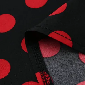 Macro view of red polka dot print on black fabric with quality hem stitching detail