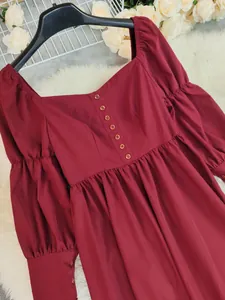 Détail du décolleté carré et des boutons sur une robe midi vintage bordeaux à manches longues