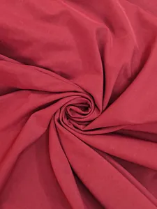 Détail d'un tissu de robe vintage bordeaux élégant avec une texture fluide en spirale