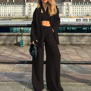 Outdoor lifestyle shot of model wearing black blazer and wide-leg trousers by the river.