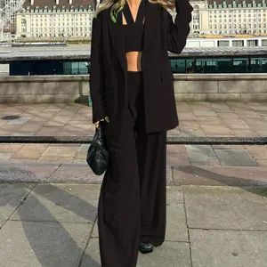 Fashionable three-piece set featuring black blazer, crop top, and wide-leg trousers