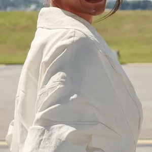 Detailopname van de stoftextuur en het kraagontwerp van een witte trenchcoat