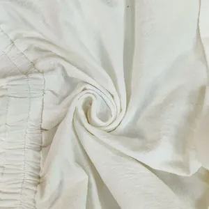 Detailed macro view showing the textured white cotton-linen fabric and elastic waistband.