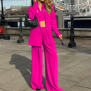 Stylish women's 3-piece magenta suit set with blazer, crop top, and wide-leg trousers.