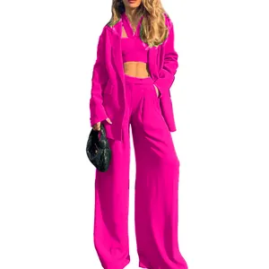 Hot pink three-piece suit featuring long-sleeve blazer, crop top, and wide-leg trousers.