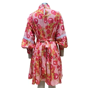 Back view of high neck floral pink dress with lantern sleeves and white lace detail.