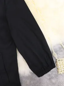 Detailopname van de elastische manchet van een zwarte lange trenchcoat voor dames