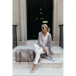 Women's grey long knitted cardigan with irregular hem in a casual lifestyle outdoor setting