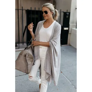 Detail shot of a stylish gray knitted cardigan featuring an irregular hem and loose fit