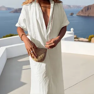 Elegante vestido camisero de lino blanco en un resort costero con bolso de paja