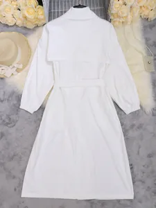 Achteraanzicht van een elegante witte halflange trenchcoat met riem en gelaagd ontwerp aan de rug.