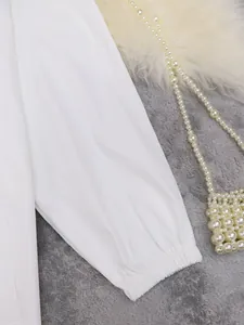 Detailopname van de elastische manchet op een witte modieuze windjas met lange mouwen