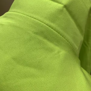 Macro detail of lime green suit fabric showing high-quality textile weave and stitching