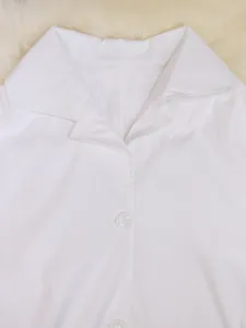 Close-up van witte trenchcoat kraag en knoop detail met hoogwaardige stoftextuur