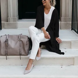Detail shot of a black long-line knit cardigan with a loose fit and irregular hem